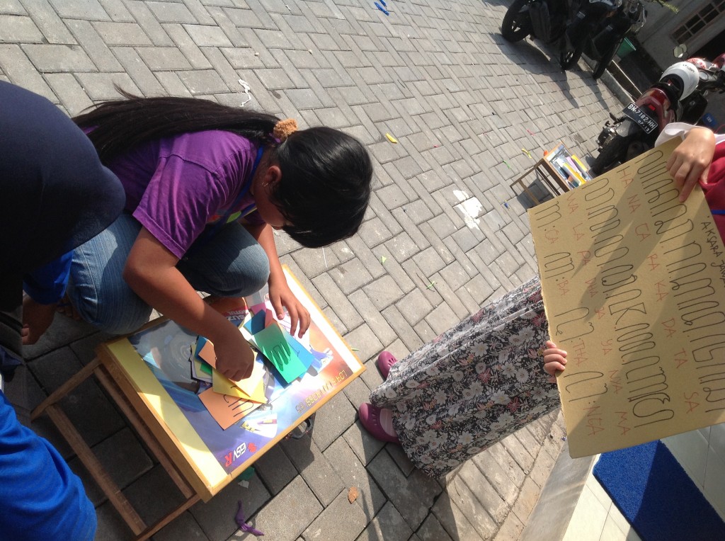 A girl arranges the pieces of paper to answer the question 